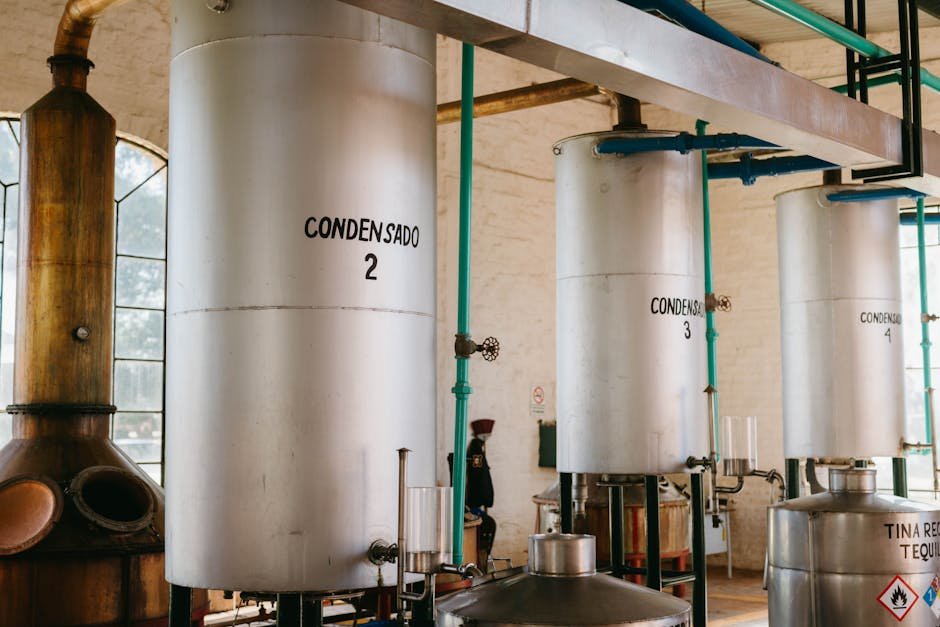pexels-photo-10040001-10040001 Interior view of industrial tequila distillery with metal tanks and pipes.