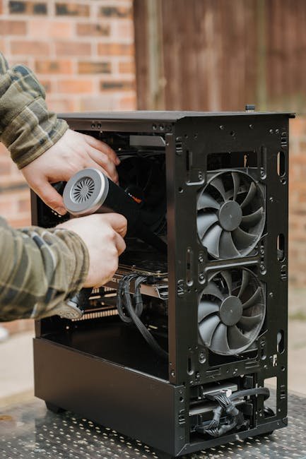pexels-photo-31854227-31854227 Hands cleaning a desktop PC case with an electric duster outdoors.