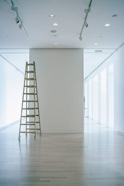 pexels-photo-4947007-4947007 Wide indoor space with a ladder, showcasing LED lighting and modern minimalism.