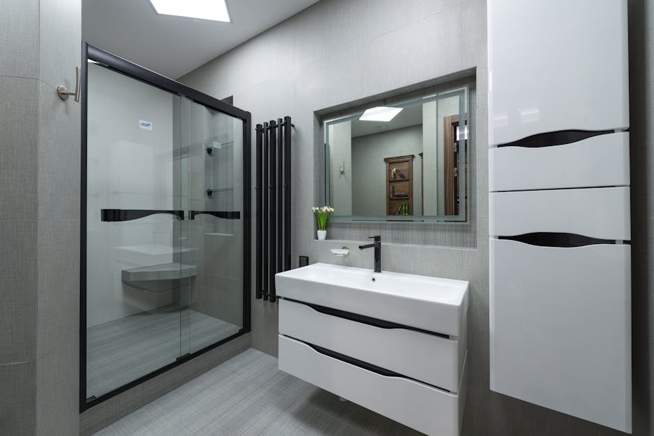 pexels-photo-7227624-7227624 White sink at wall with mirror near cupboard in modern bathroom with glass shower cabin and bright illumination in apartment
